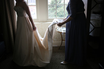 Mother of the Bride Adjusting the Train of The Bride's Wedding Gown