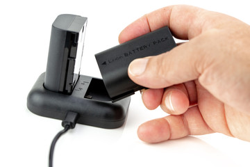 Man manipulating Camera battery and charger