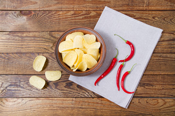 top view potato chips and red chili peper on wooden table,tablecloth