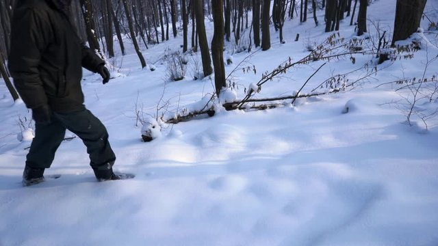 Man goes through snowy forest - (4K)