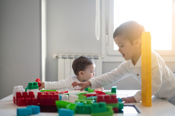 Obraz premium Two happy baby playing with toy blocks.