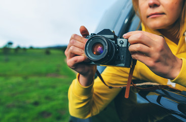 smile tourist girl in an open window of a auto car taking photography click on retro vintage photo...