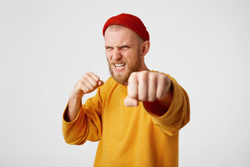Young strong man with a beard show anger, strikes a fist, box,fights, attacks, protects, isolated...