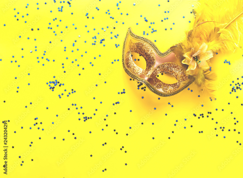 Poster carnival mask on yellow background with sparkles. festive backdrop for projects.
