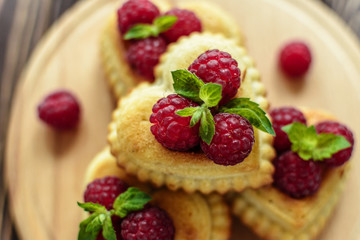 Delicious heart-shaped muffins with raspberries and mint. Cupcakes for Valentine's Day