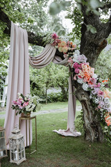 Wedding ceremony. A very beautiful wedding arch on the tree is decorated with many fresh beautiful...