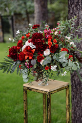 Bridal bouquet. Lush beautiful bouquet of red and white roses, lilies, peonies and greenery outdoors