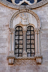 Fototapeta na wymiar Cattedrale di Ruvo di Puglia; bifora in facciata con immagine di San Michele Arcangelo in bassorilievo