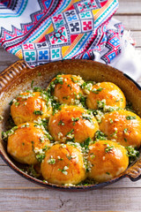 Buns Pampushky - Ukrainian garlic bread. Bread rolls with garlic and parsley in baking dish