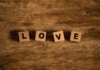 Love text written with wood blocks on rustic vintage background