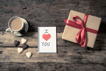 Conceptual Valentines image of note book with space for text, heart shaped chocolates and coffee