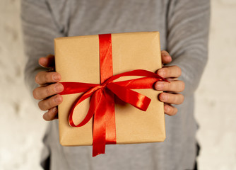 Close up o woman holding beautiful gift box wrapped with red ribbon for Valentines and anniversary