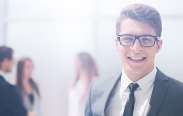smiling young businessman on blurred office background.