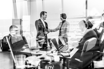 Sealing a deal. Business people shaking hands, finishing up meeting in corporate office. Business...