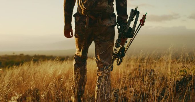 Experienced bowhunter slowly walks out to viewpoint