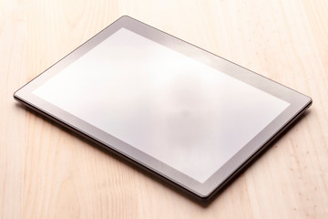 Black digital tablet on a wooden table