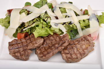 Grilling steaks  with salad and  Parmesan cheese