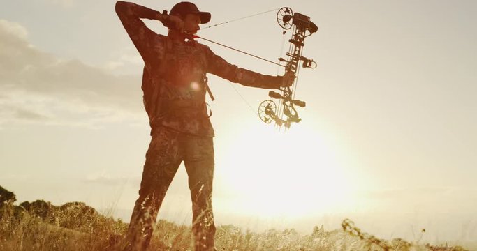 Orbit shot of majestic bowhunter aiming his bow