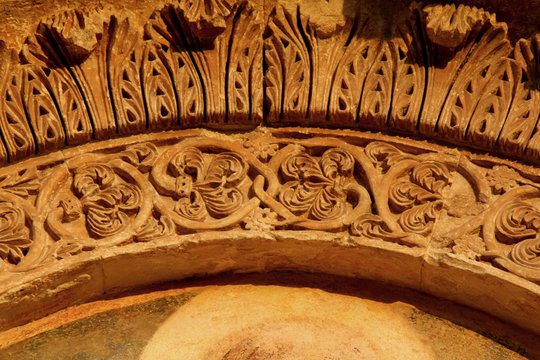 corona di foglie d'acanto e motivi floreali; arco del portale della chiesa dell'Abbazia di Santa Maria di Cerrate (Puglie)