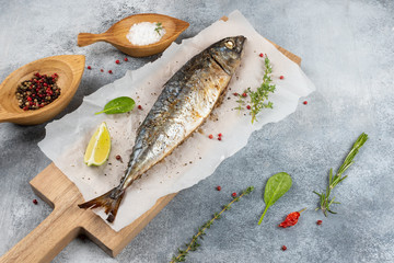 Baked mackerel fish on gray concrete background, top view