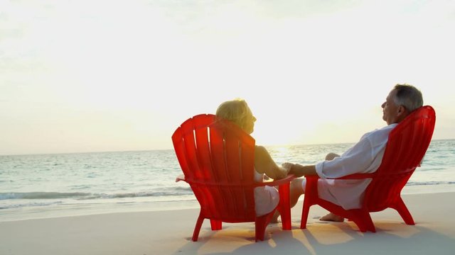 Caucasian couple relaxing on chairs together romantic Caribbean