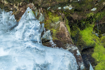 ice block covered rock surface filled with green mosses background