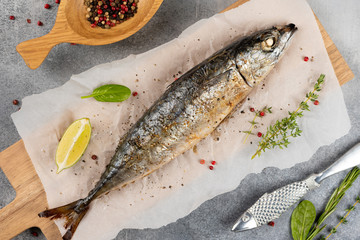 Baked mackerel fish on gray concrete background, top view