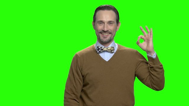 Handsome friendly middle aged man with okay sign gesture. Green screen hromakey background for keying.