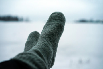 View of warm socks on legs on snowy background.