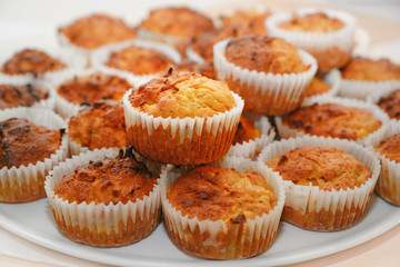 homemade carrot muffins in paper sleeves served on a white tray