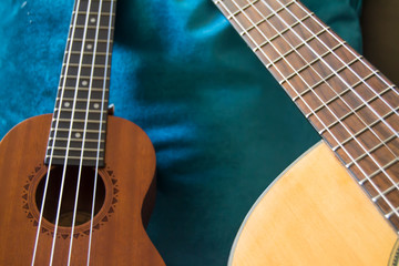 ukulele and acoustic guitar with blue background