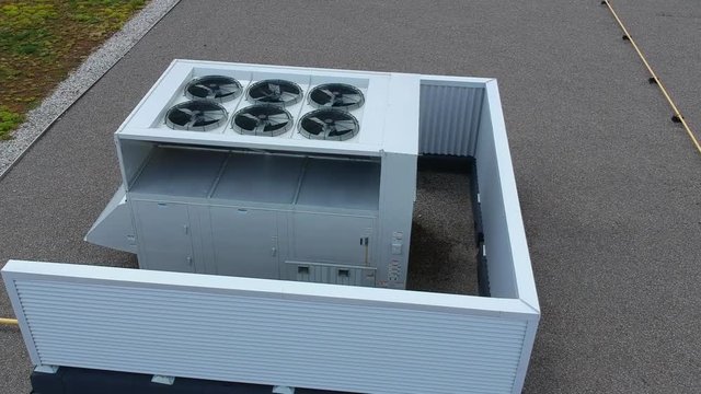 Aerial top view footage of AC exhaust vents of industrial air conditioning and ventilation at roof at hot summer day.