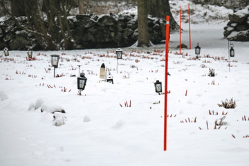 Lanterns with candles at the cemetery grave yard covered with snow in winter