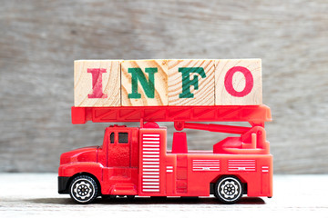 Toy fire ladder truck hold letter block in word info on wood background