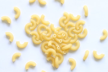 Heart made of macaroni pasta on white background