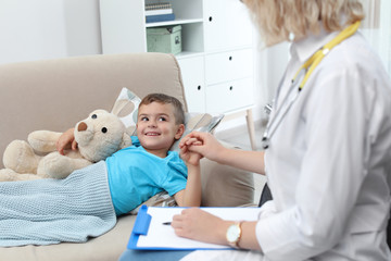 Children's doctor visiting little boy at home