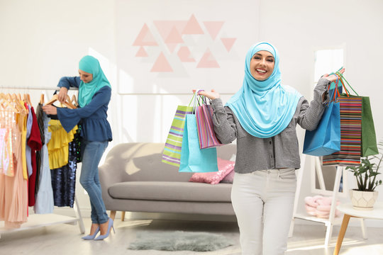 Muslim woman with shopping bags in modern shop