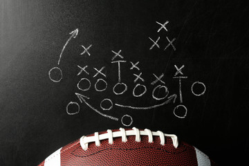 Chalkboard with football game scheme and rugby ball, top view