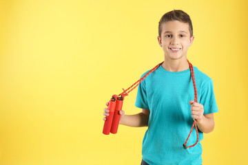 Boy with jump rope on color background. Space for text