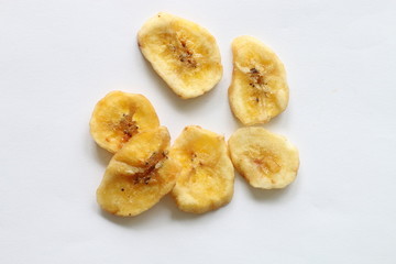 Dried banana chips on white background