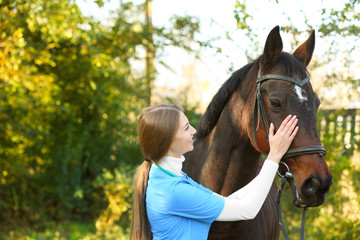 Obraz premium Veterinarian in uniform with beautiful brown horse outdoors. Space for text