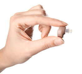 Woman holding hearing aid on white background, closeup