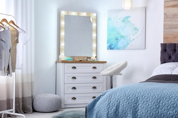 Room interior with makeup mirror, dressing table and bed