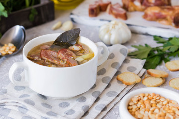 Thick pea soup with smoked meats in a white plate