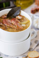 Thick pea soup with smoked meats in a white plate