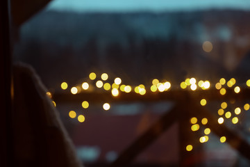 Blurred view of fence decorated with Christmas lights