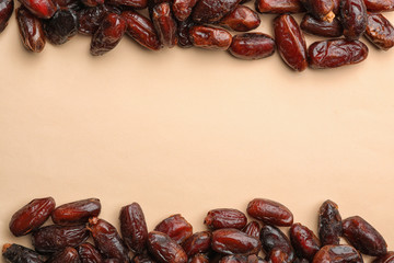 Frame made of sweet dried date fruits on color background, top view with space for text