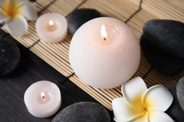 Spa stones, candles and flowers on table, closeup