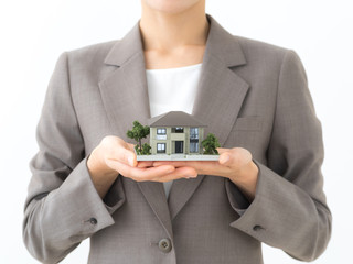 住宅模型を持つ女性