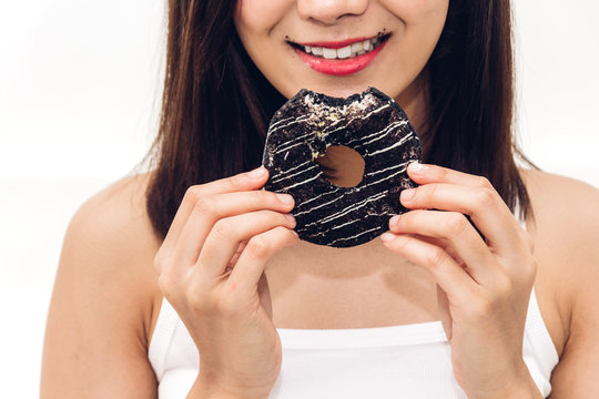 Beautiful woman enjoy eating chocolate donut cake at home.unhealthy and Junk food concept